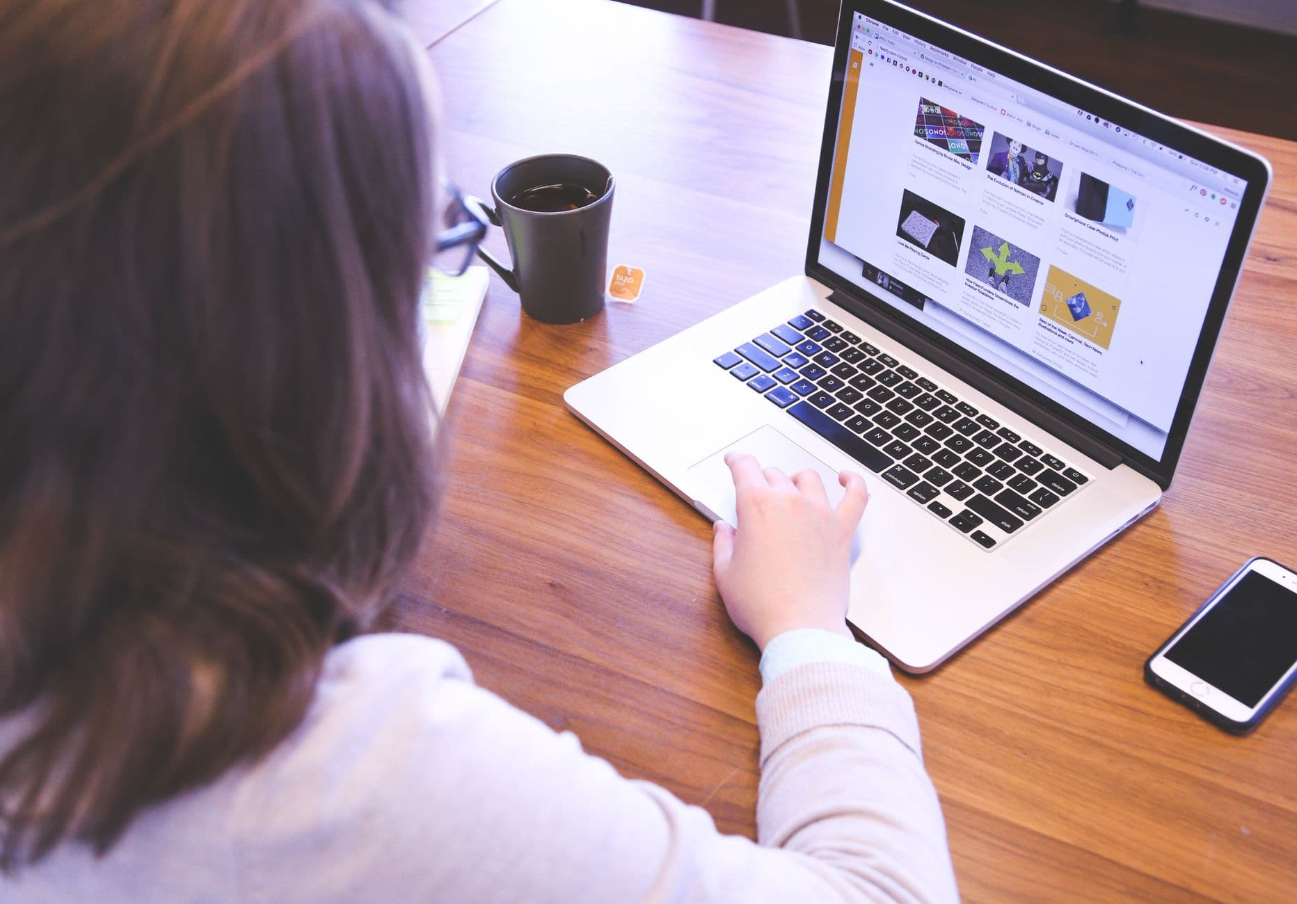 A person browsing websites on a laptop and phone, where display banner ads appear
