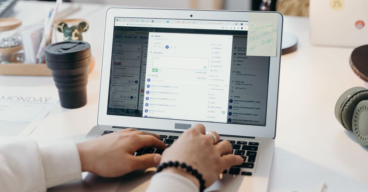 A person writing a restaurant email campaign on a laptop at a bright desk