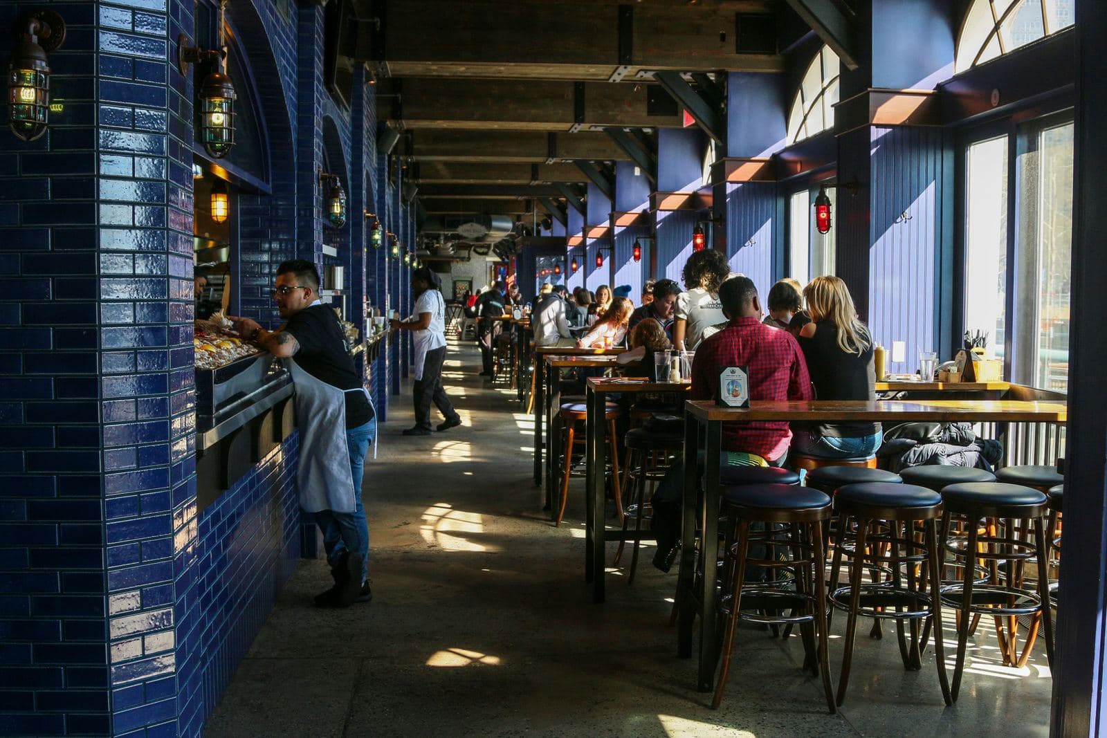 A busy restaurant dining room full of customers enjoying their meals