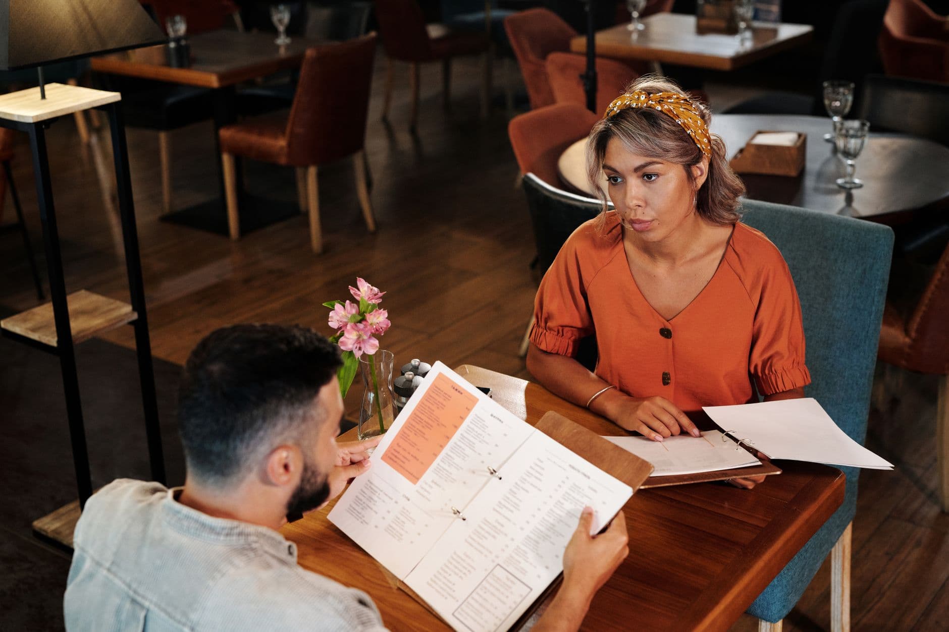 Two diners reading a restaurant menu together at a table