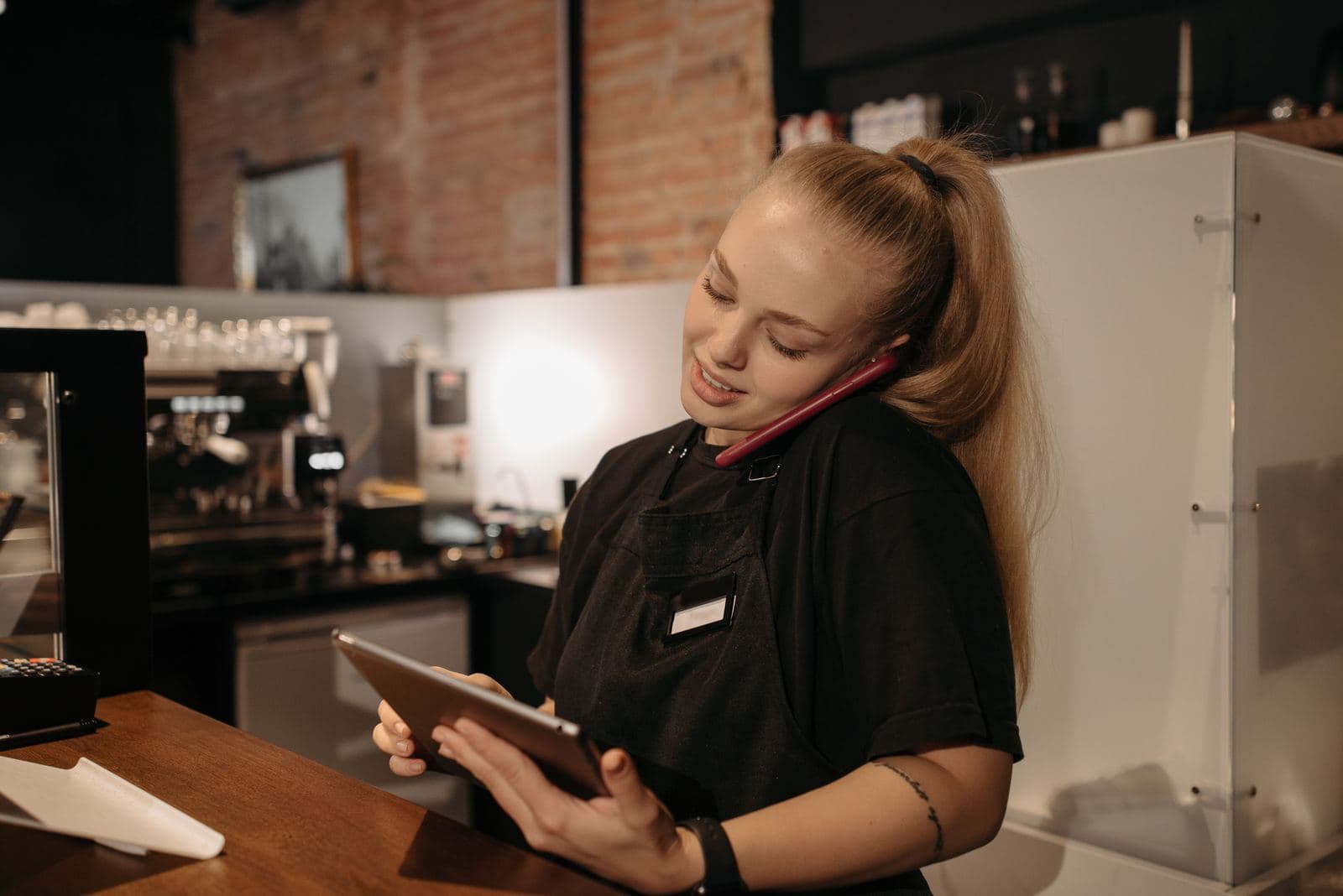 A café team member checking an order on a tablet behind the counter